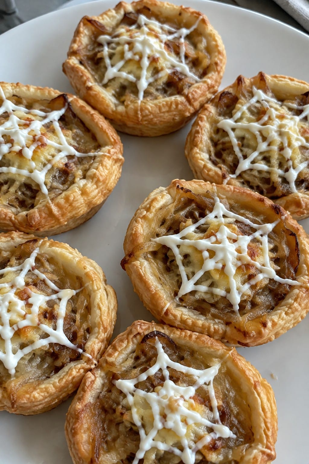 Caramelized Onion and Gruyère Spiderweb Tartlets