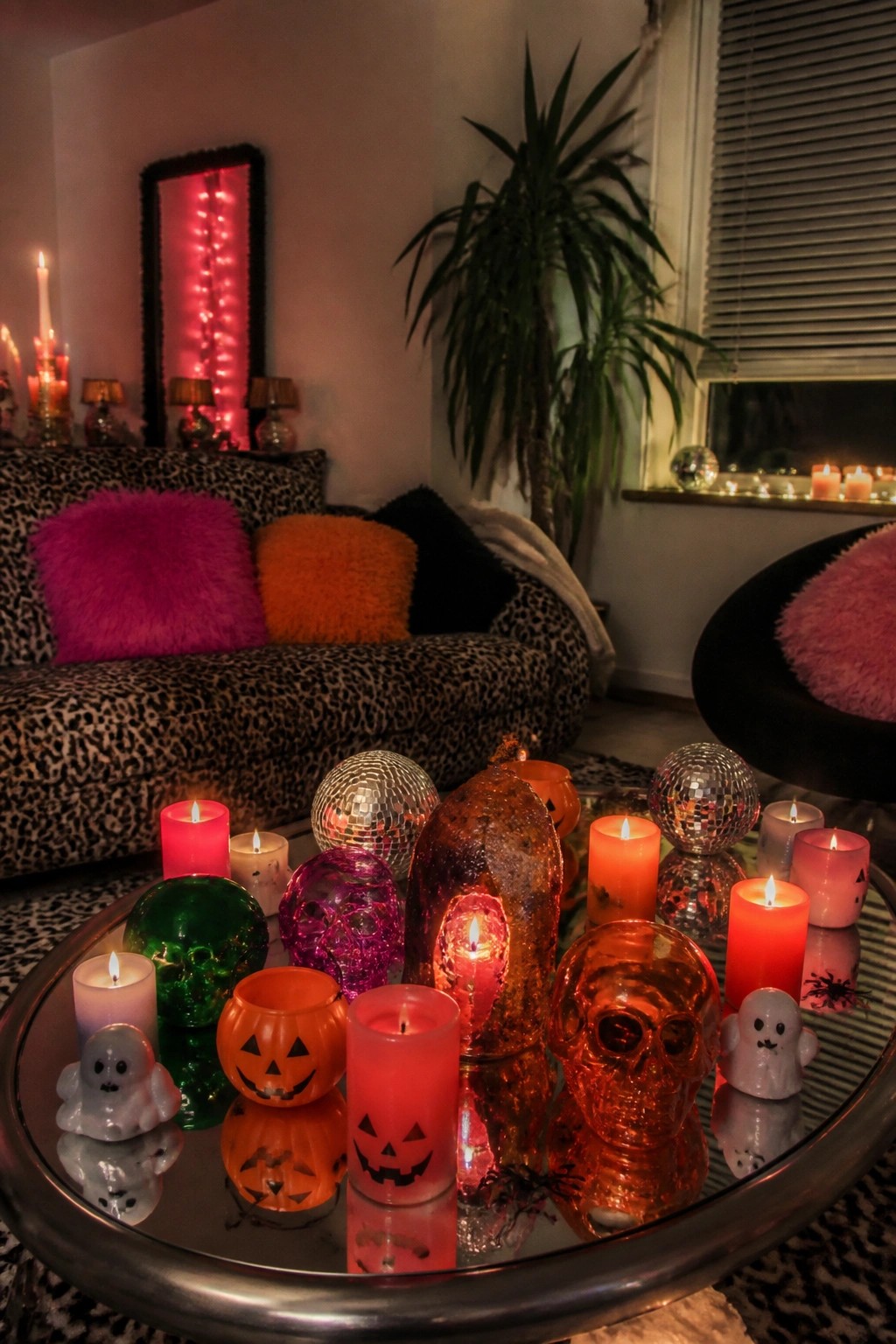 Lit Halloween candles in skull, pumpkin, and ghost holders with disco balls